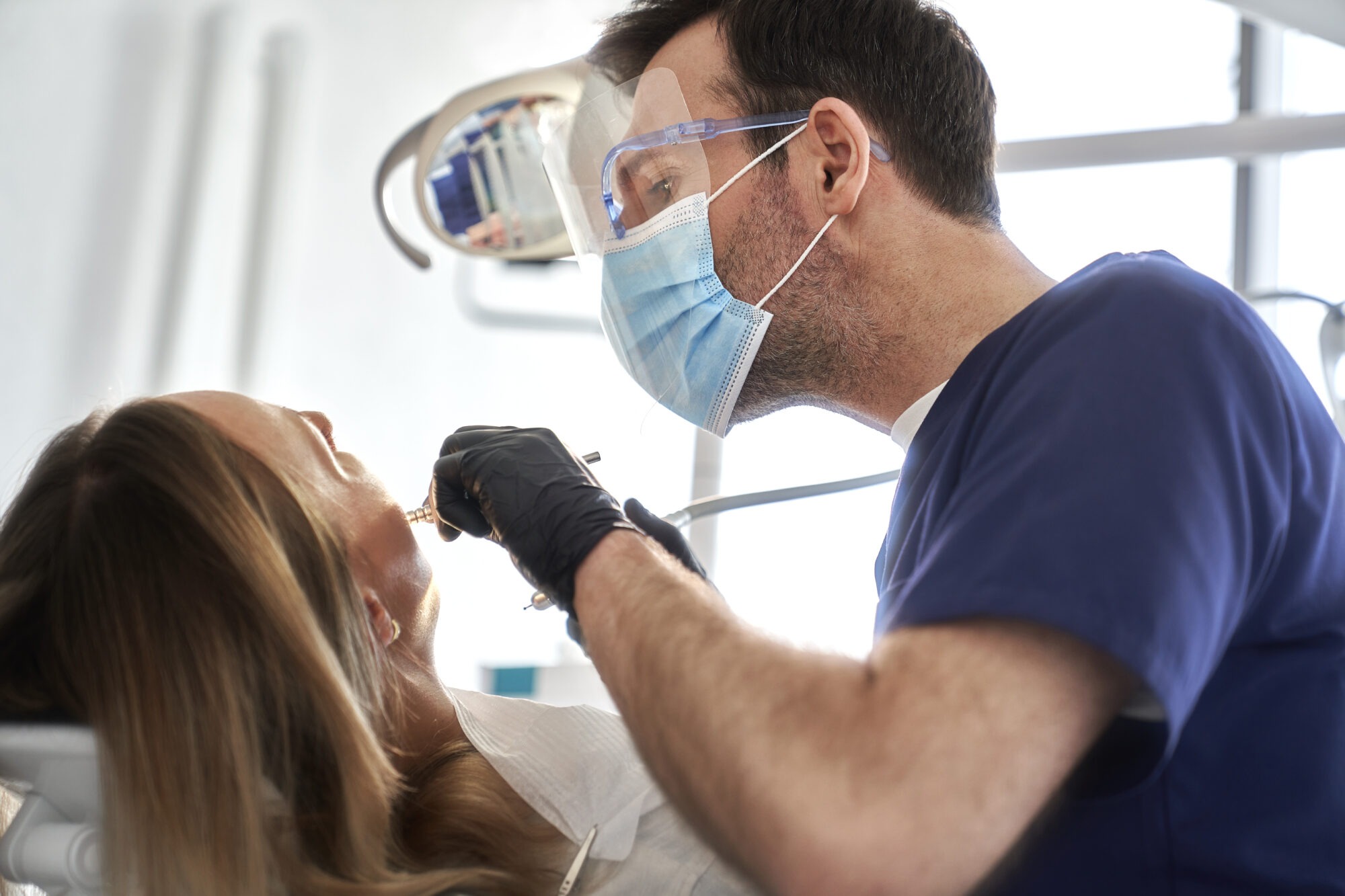 Comprehensive Dental Treatment at Boca Center Dental | Boca Raton Dentist Dentist performing dental treatment for a patient at Boca Center Dental in Boca Raton, FL